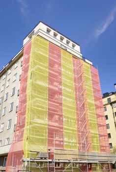 Thermal insulation being installed with scaffolding around the building