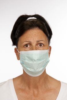 Vertical shot of woman wearing a protective mask and looking afraid of catching germs