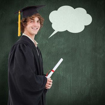 Profile view of a student in graduate robe against green chalkboard