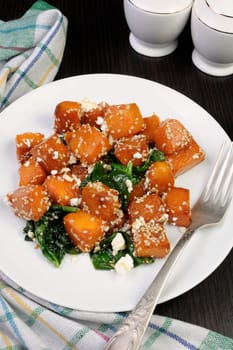 Slices of pumpkin baked with spinach and sesame seeds