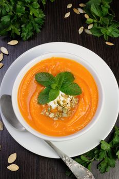 Pumpkin soup with sour cream sauce flavored  pumpkin seeds  and mint