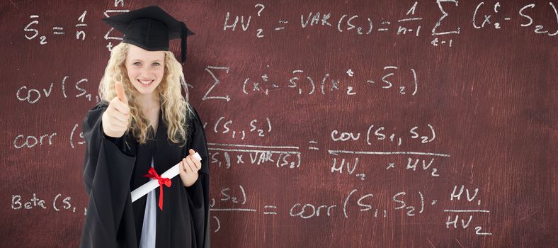 Teenage Girl Celebrating Graduation with thumbs up against desk