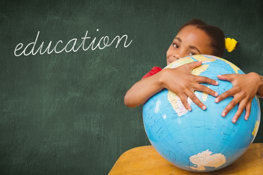 The word education and pupil hugging globe against green chalkboard
