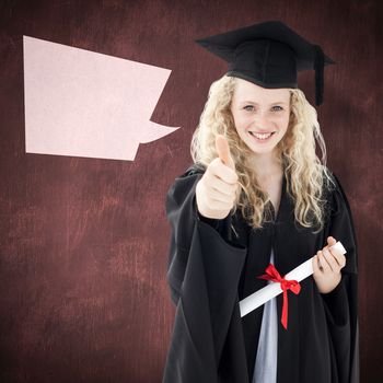 Teenage Girl Celebrating Graduation with thumbs up against desk
