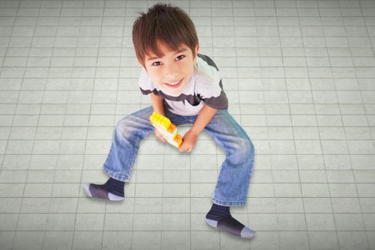 Cute boy sitting with building blocks against textured background