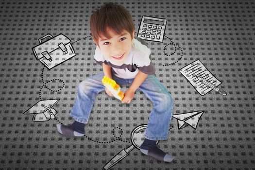 Cute boy sitting with building blocks against textured background