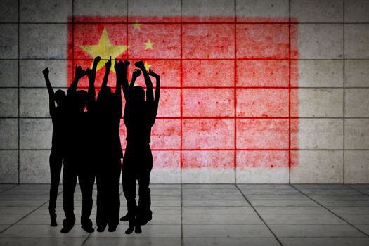 Silhouette of cheering people against china