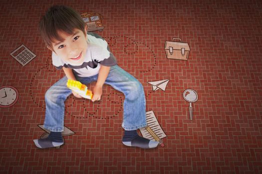 Cute boy sitting with building blocks against textured background