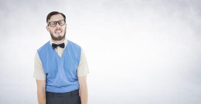 Geeky hipster pulling a silly face against white wall