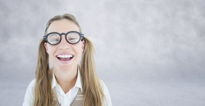 Female geeky hipster smiling at camera against grey wall