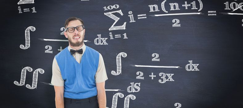 Geeky hipster pulling a silly face against blackboard