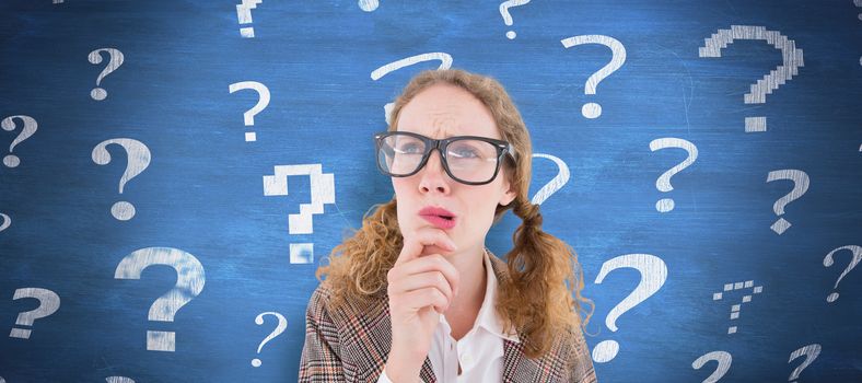 Geeky hipster woman thinking with hand on chin against blue chalkboard