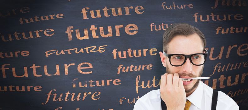 Geeky hipster biting on pencil against blackboard