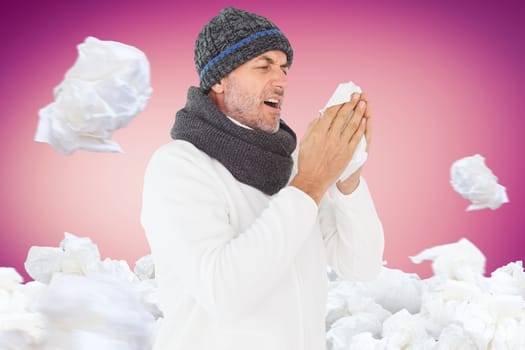 Sick man in winter fashion sneezing against pink vignette