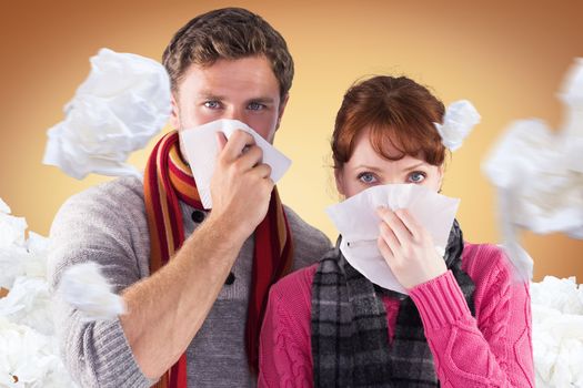 Couple blowing noses into tissues against orange vignette