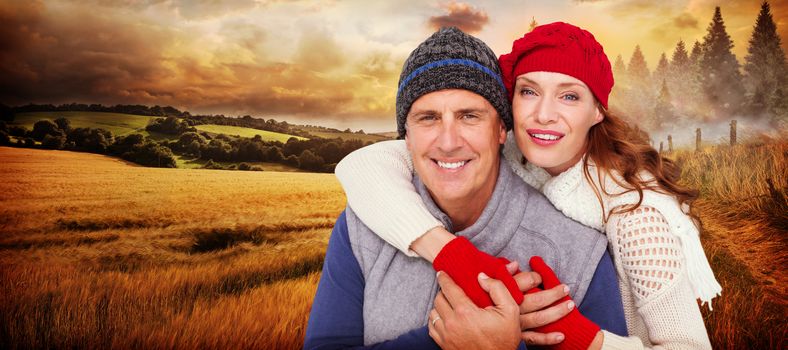 Happy couple in warm clothing against country scene