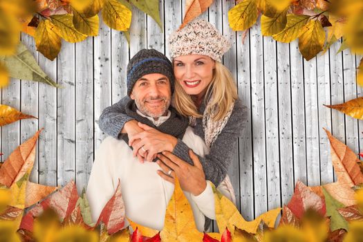 Portrait of wife embracing husband against digitally generated grey wooden planks