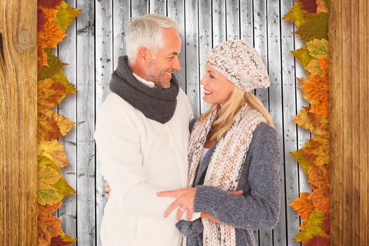 Cute happy couple romancing against digitally generated grey wooden planks