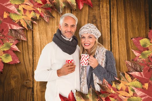 Portrait of happy couple drinking hot coffee against wooden table