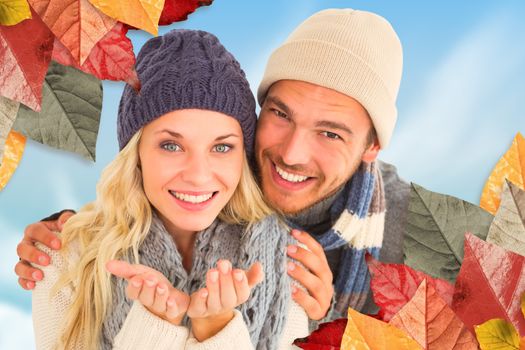 Attractive couple in winter fashion smiling at camera against blue sky