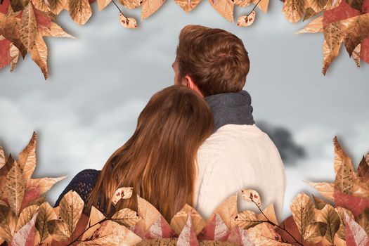 Close up rear view of romantic couple against mountain peak through the clouds