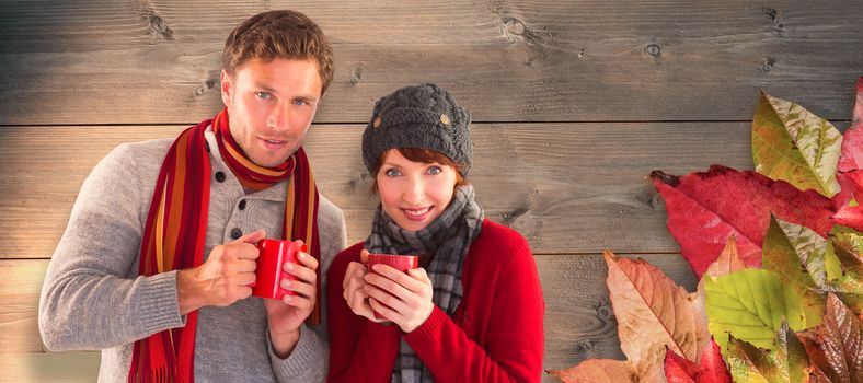 Couple both having warm drinks against bleached wooden planks background