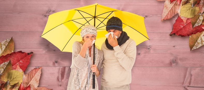 Couple sneezing in tissue while standing under umbrella against bleached wooden planks background