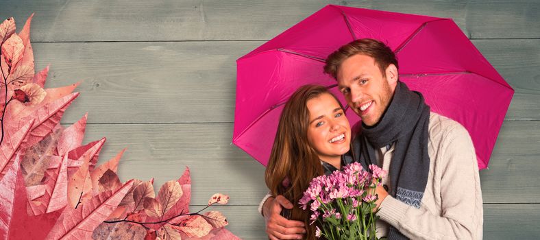 Cheerful young couple with flowers and umbrella against bleached wooden planks background