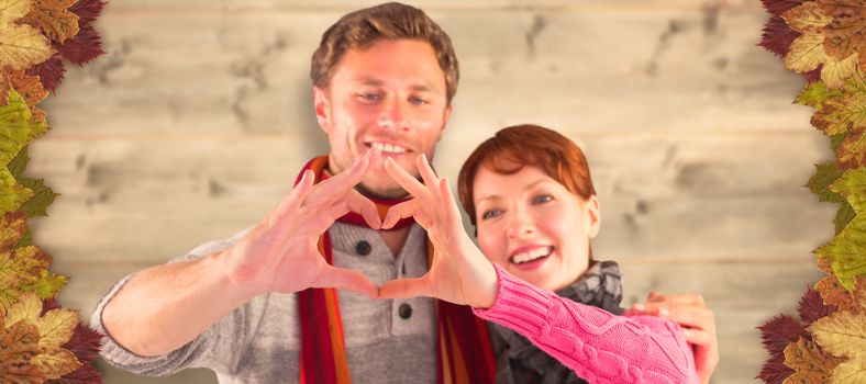 Couple making a heart shape against bleached wooden planks background