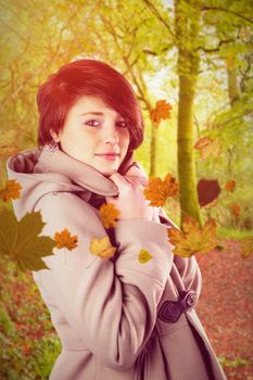 Portrait of beautiful woman wearing winter coat  against peaceful autumn scene in forest