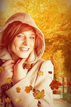 Portrait of smiling woman wearing winter coat against autumn scene