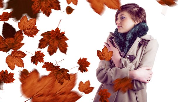Thoughtful woman in winter coat against autumn leaves