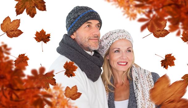 Cheerful couple in warm clothing against autumn leaves