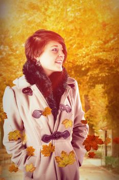 Smiling beautiful woman in winter coat against autumn scene