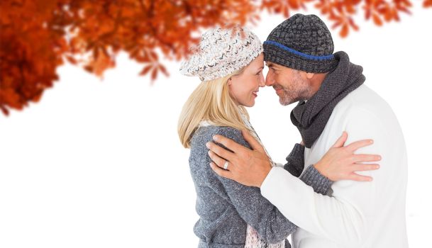 Smiling cute couple romancing over white background against autumn leaves