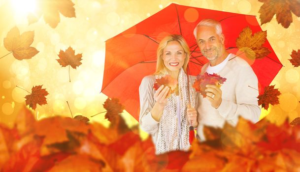 Portrait of happy couple under red umbrella against yellow abstract light spot design