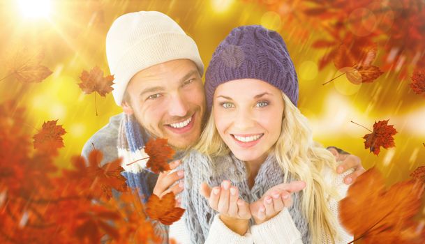 Attractive couple in winter fashion smiling at camera against park