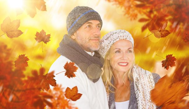 Cheerful couple in warm clothing against wooden trail across countryside
