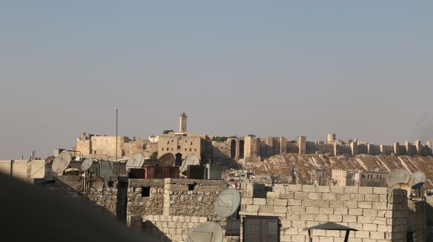 SYRIA, Aleppo: The Citadel of Aleppo on September 2, 2015. A glimpse into Aleppo reveals a city destroyed by violence and war.  Little remains of the once populous city, on UNESCO's World Heritage list. Homes, businesses, and basic infrastructure have been severely damaged by years of civil war. The dangerous and unstable conditions are fueling a mass exodus of refugees from Syria into Europe.  The city of Aleppo also serves as an ISIS stronghold. 