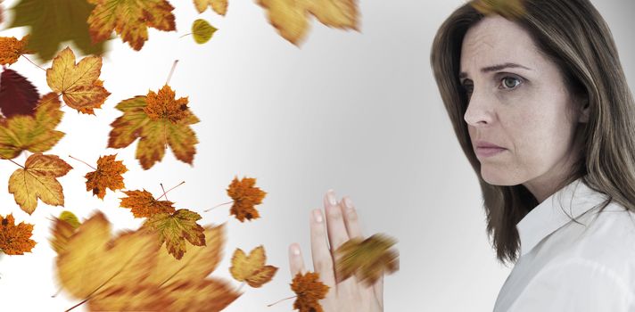 Depressed businesswoman looking away against autumn leaves