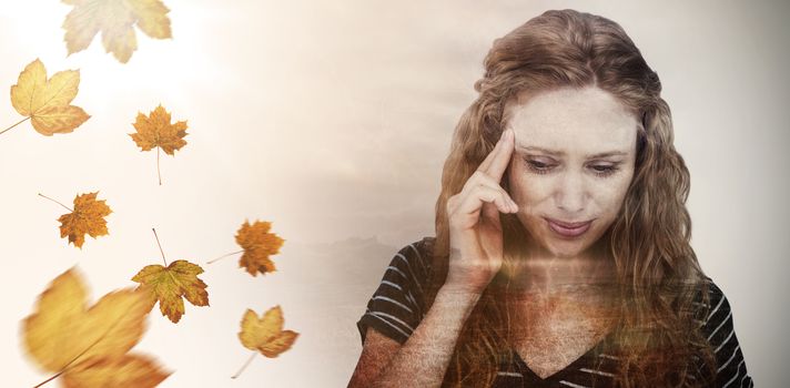 Blonde woman having headache against autumn leaves pattern