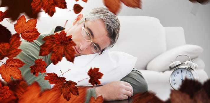 Man resting on cushion against autumn leaves