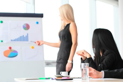 Workers at business meeting looking at presentation of financial reports in modern office