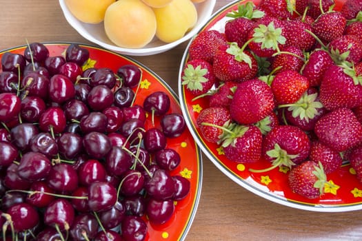 Background with fresh cherryes strawberries and apricots