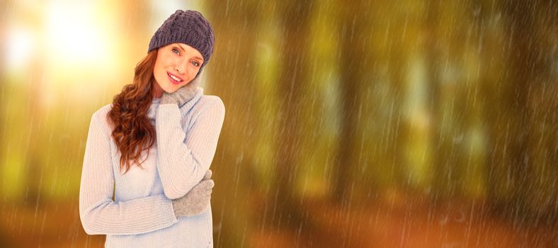 Pretty redhead in warm clothing against autumn scene