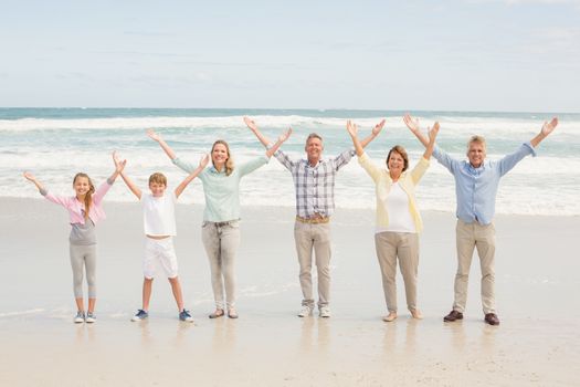 Multi generation family standing beside one another at the beach