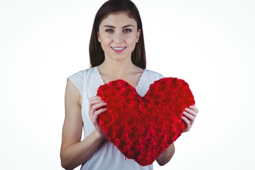 Woman holding heart shape cushion on white background