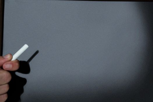 Close-up of teacher ready to write on blackboard