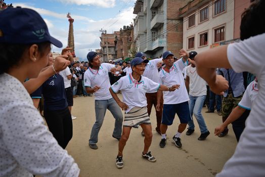 NEPAL, Patan: Nepalese men dance as Hindu and Buddhist devotees celebrate the festival of rain god Rato Machindranath in Patan, Nepal on September 22, 2015. The festival takes place each April, but was delayed this year after a devastating earthquake damaged the chariot that devotees pull through the area in the hope of securing a good harvest.