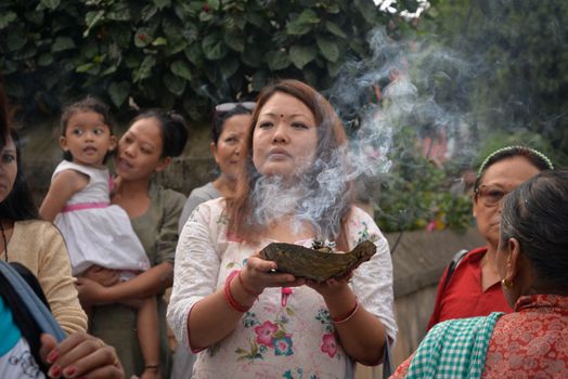 NEPAL, Patan: A woman looks on as Hindu and Buddhist devotees celebrate the festival of rain god Rato Machindranath in Patan, Nepal on September 22, 2015. The festival takes place each April, but was delayed this year after a devastating earthquake damaged the chariot that devotees pull through the area in the hope of securing a good harvest.